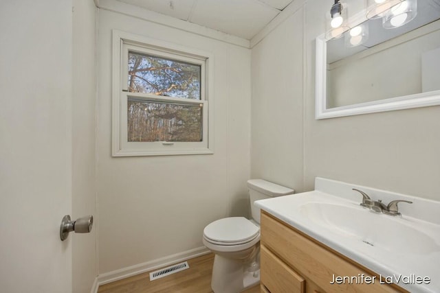 bathroom featuring vanity, wood-type flooring, and toilet