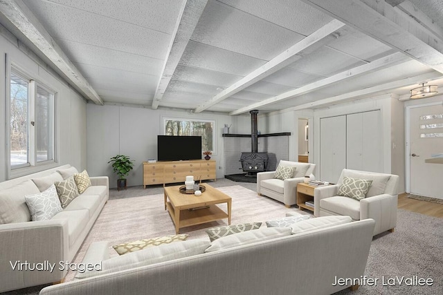 living room with beamed ceiling and a wood stove