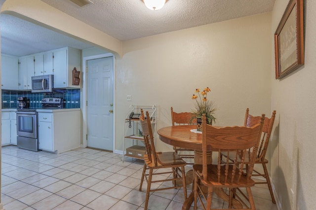 dining space featuring light tile patterned floors and a textured ceiling