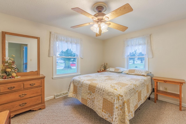 carpeted bedroom with a textured ceiling and ceiling fan