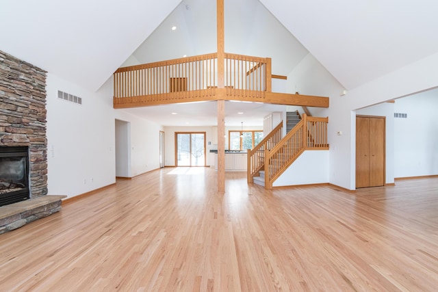 unfurnished living room featuring a stone fireplace and light hardwood / wood-style floors