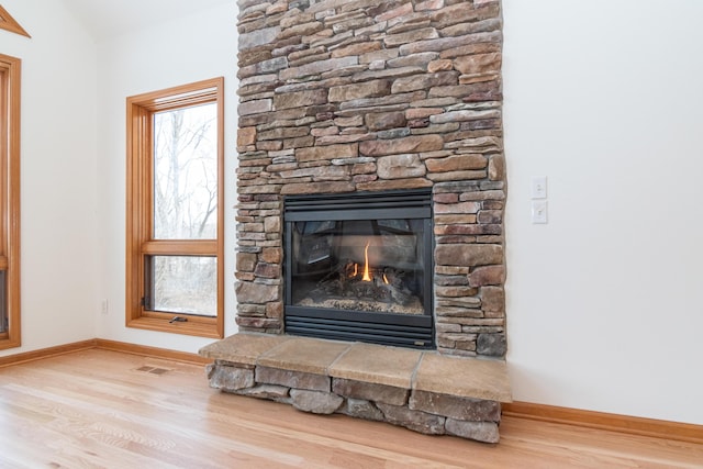 room details featuring a stone fireplace and hardwood / wood-style floors