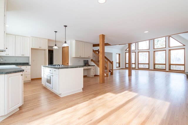 kitchen with a center island, light hardwood / wood-style floors, hanging light fixtures, and white cabinets