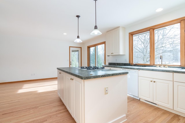 kitchen featuring sink, white cabinetry, decorative light fixtures, dishwasher, and a kitchen island