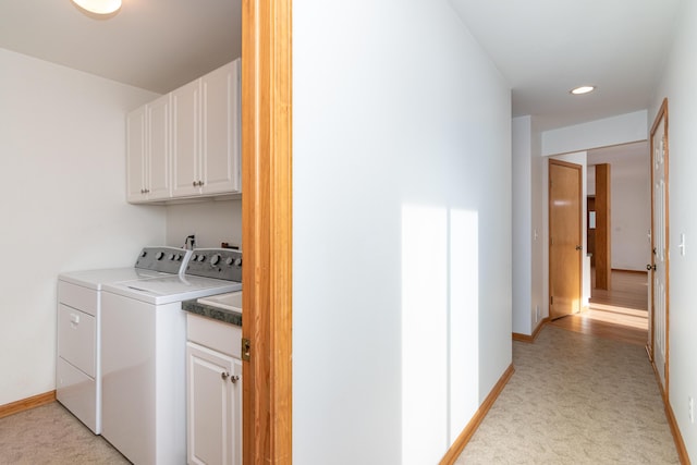 washroom featuring cabinets, washer and dryer, and light carpet