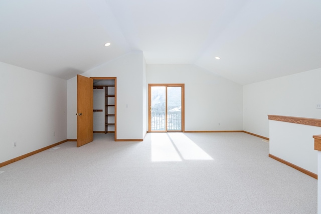 additional living space with light colored carpet and vaulted ceiling