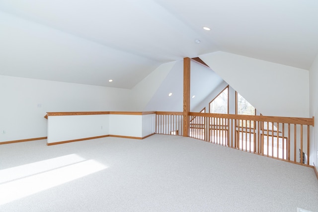 bonus room with vaulted ceiling and carpet