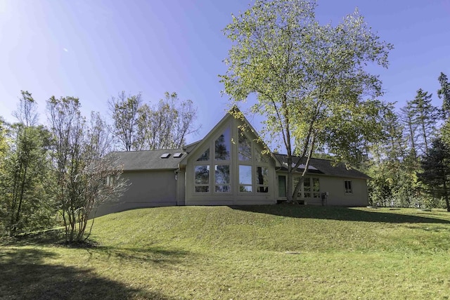 rear view of property featuring a lawn