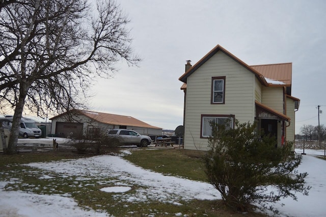 view of snow covered exterior featuring a garage