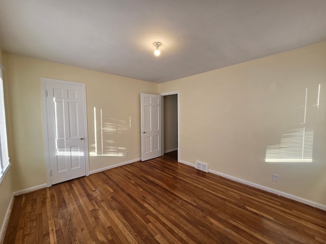 unfurnished bedroom with dark hardwood / wood-style floors