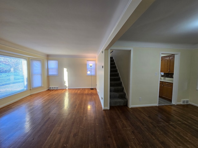 unfurnished living room with dark wood-type flooring