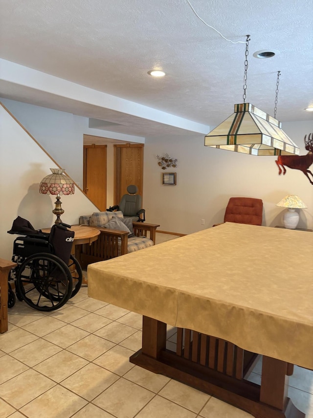 rec room featuring light tile patterned floors, pool table, and a textured ceiling