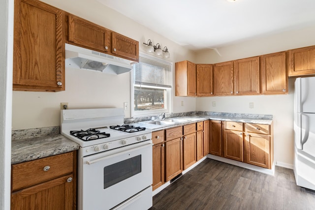 kitchen featuring dark wood-type flooring, white appliances, and sink