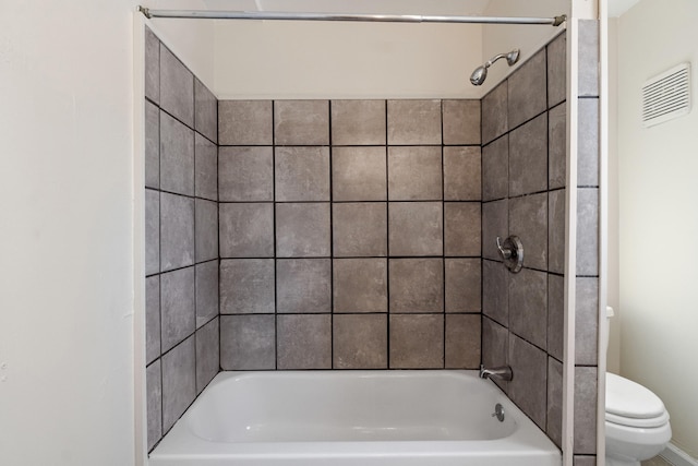 bathroom featuring tiled shower / bath and toilet