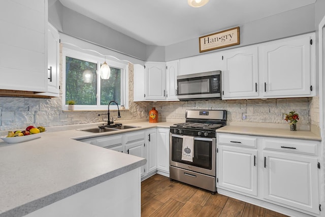 kitchen featuring appliances with stainless steel finishes, sink, white cabinets, and backsplash