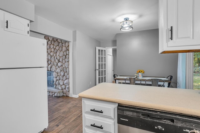 kitchen featuring white refrigerator, white cabinetry, wood-type flooring, and stainless steel dishwasher