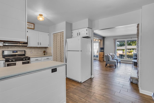 kitchen featuring light hardwood / wood-style flooring, white cabinetry, backsplash, white refrigerator, and stainless steel range with gas cooktop