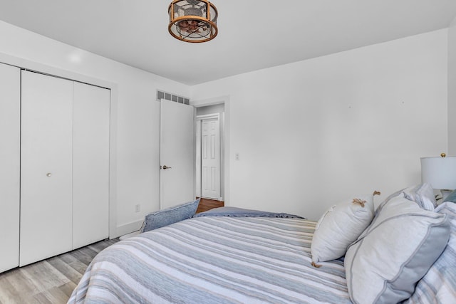 bedroom with light hardwood / wood-style floors and a closet