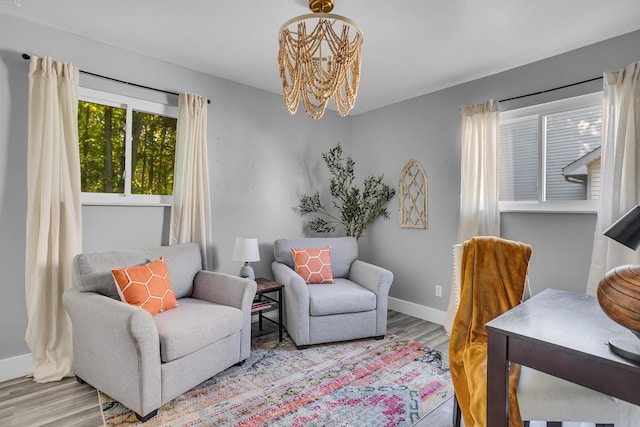 sitting room with a notable chandelier and light hardwood / wood-style floors