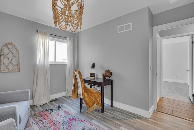 office area with a notable chandelier and light hardwood / wood-style flooring