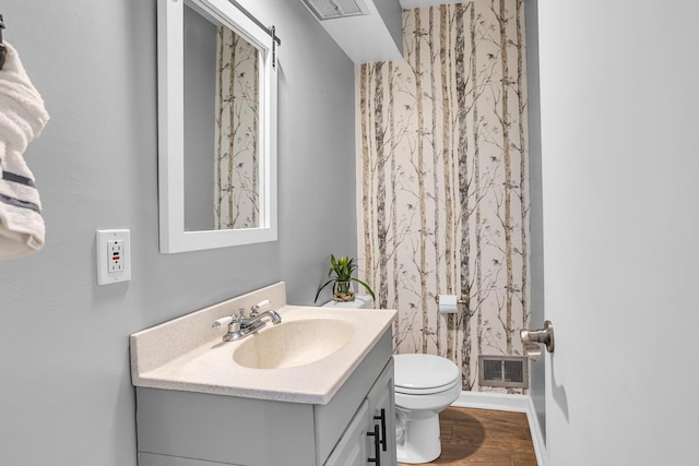 bathroom with vanity, hardwood / wood-style flooring, and toilet