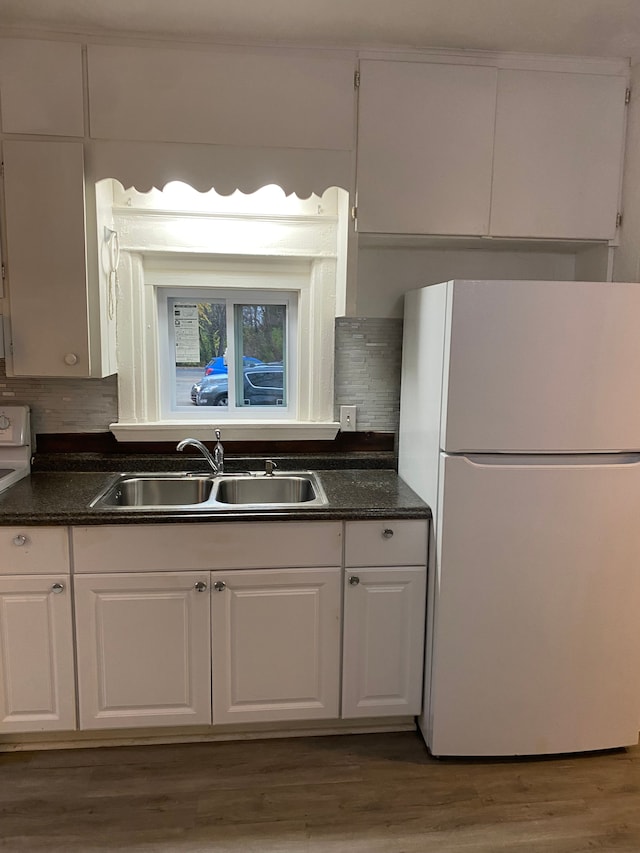 kitchen featuring backsplash, sink, white fridge, and white cabinets