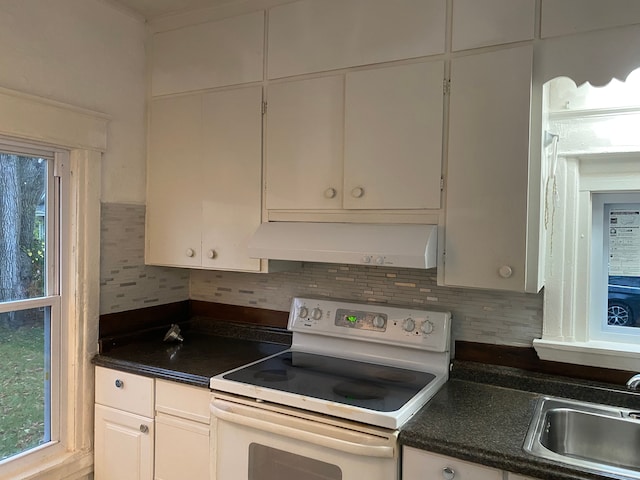 1192 S Belsay Rd, Burton, MI 48509 - kitchen featuring white range with electric stovetop, under cabinet range hood, a sink, backsplash, and dark countertops