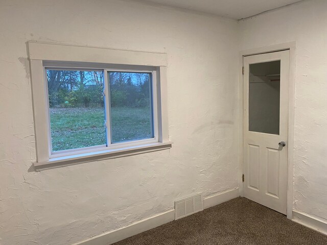 1192 S Belsay Rd, Burton, MI 48509 - unfurnished room featuring dark carpet, baseboards, and a textured wall