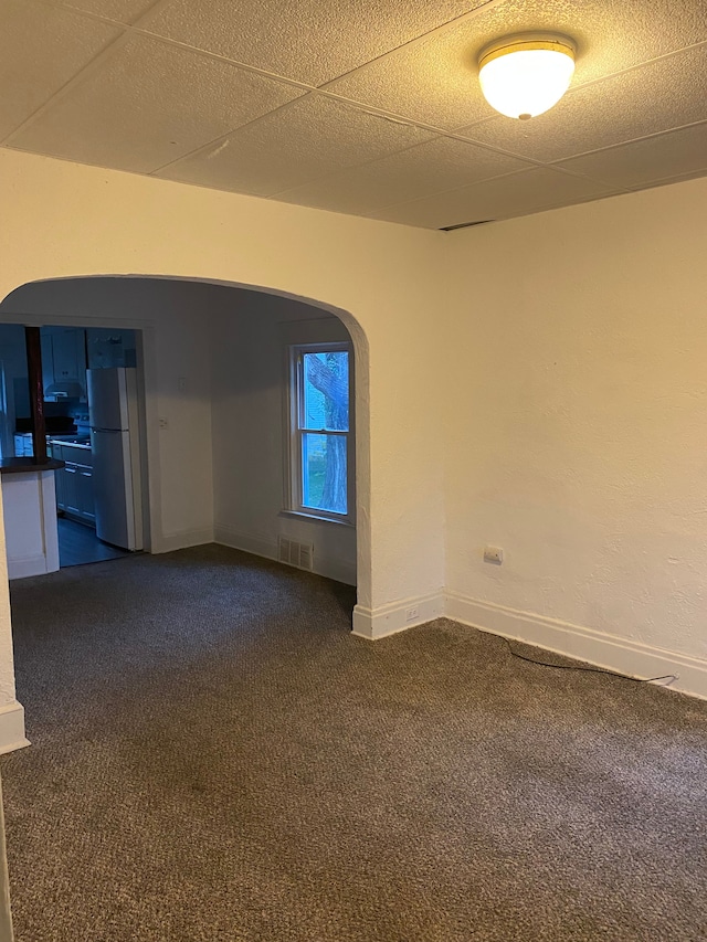 1192 S Belsay Rd, Burton, MI 48509 - empty room featuring dark carpet, arched walkways, and baseboards