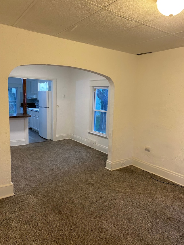 carpeted spare room with a drop ceiling