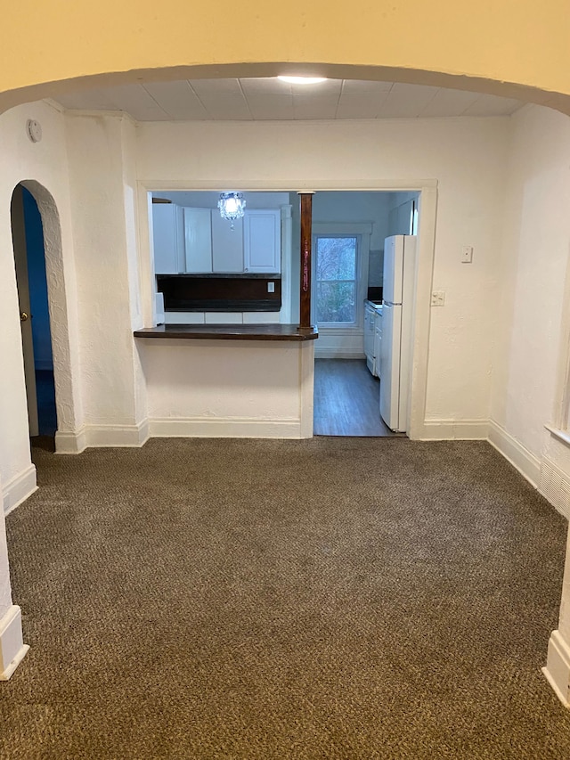 unfurnished living room featuring dark colored carpet