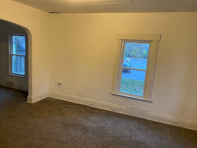 carpeted spare room with a drop ceiling