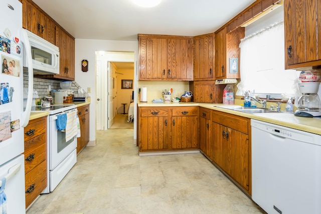 kitchen featuring tasteful backsplash, white appliances, and sink