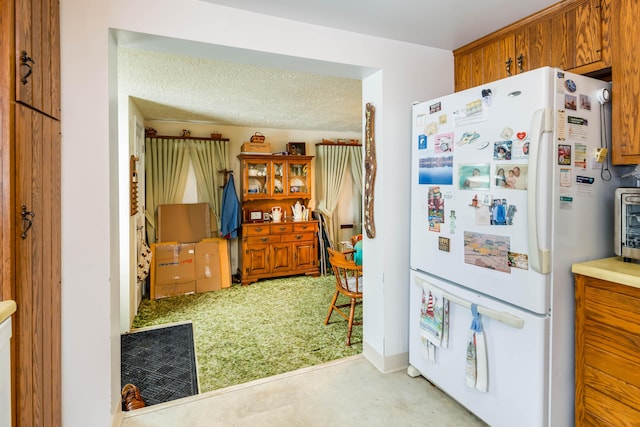 kitchen featuring white refrigerator and a textured ceiling