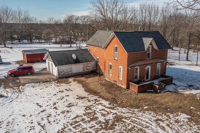 view of snowy exterior featuring an outbuilding