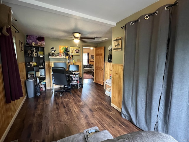 office area featuring dark wood-type flooring, wooden walls, and ceiling fan