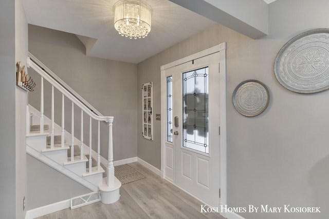 foyer with an inviting chandelier and light hardwood / wood-style floors