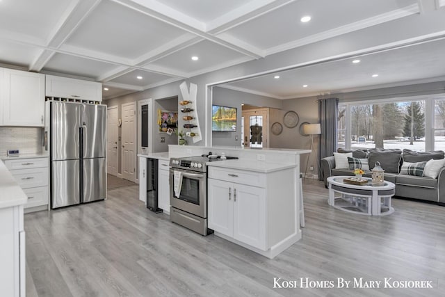 kitchen with coffered ceiling, light hardwood / wood-style floors, white cabinets, and appliances with stainless steel finishes