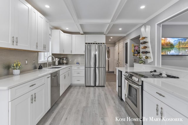 kitchen featuring coffered ceiling, sink, white cabinetry, light hardwood / wood-style flooring, and appliances with stainless steel finishes