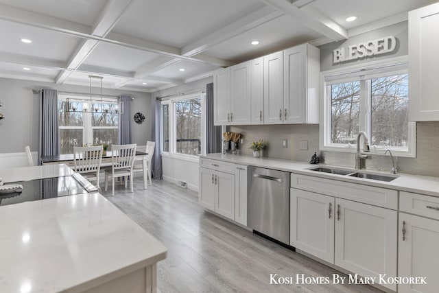 kitchen featuring sink, tasteful backsplash, stainless steel dishwasher, light hardwood / wood-style floors, and white cabinets