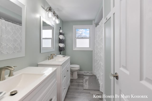 bathroom featuring hardwood / wood-style flooring, vanity, and toilet