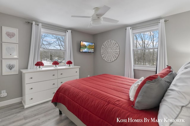 bedroom with multiple windows, ceiling fan, and light wood-type flooring