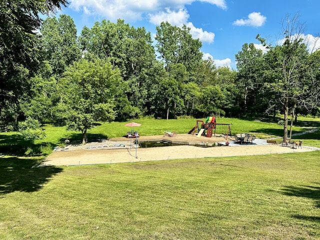 view of property's community featuring an outdoor fire pit, a yard, and a playground