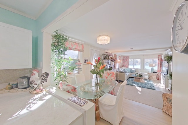 dining room featuring crown molding, light wood-type flooring, and a chandelier