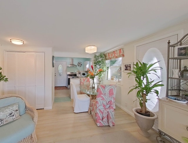 dining room with ornamental molding and light hardwood / wood-style flooring