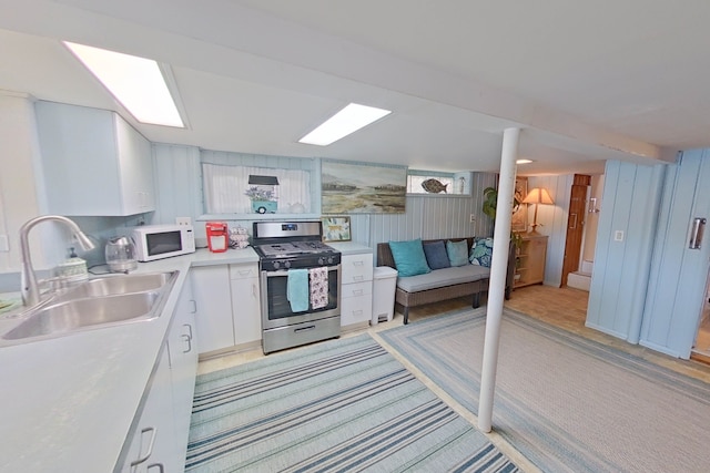 kitchen with white cabinetry, sink, and stainless steel gas stove