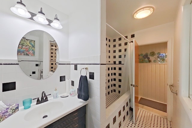 bathroom featuring walk in shower, tile patterned floors, vanity, and tile walls