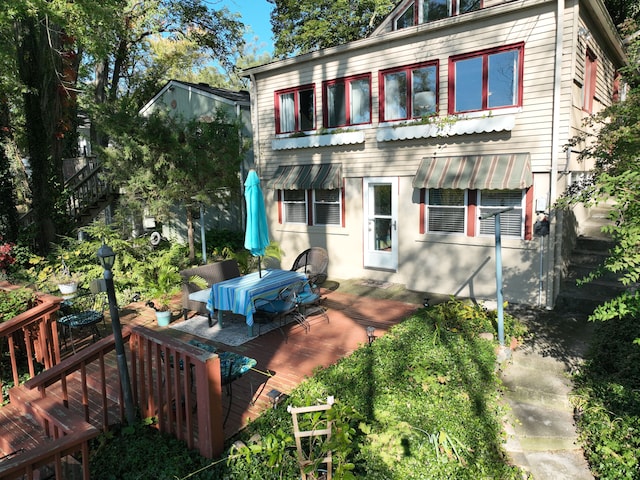 rear view of property featuring a wooden deck