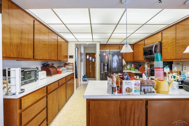 kitchen with appliances with stainless steel finishes and decorative light fixtures