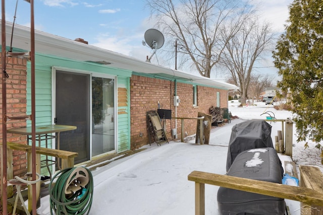 snow covered patio featuring a grill